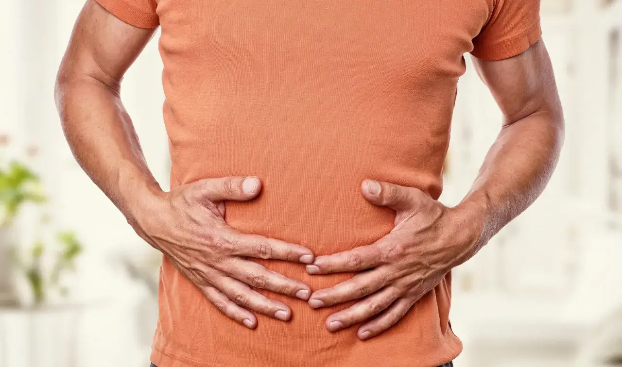 Mann hält sich den Bauch, da es im Bauch gluckert.