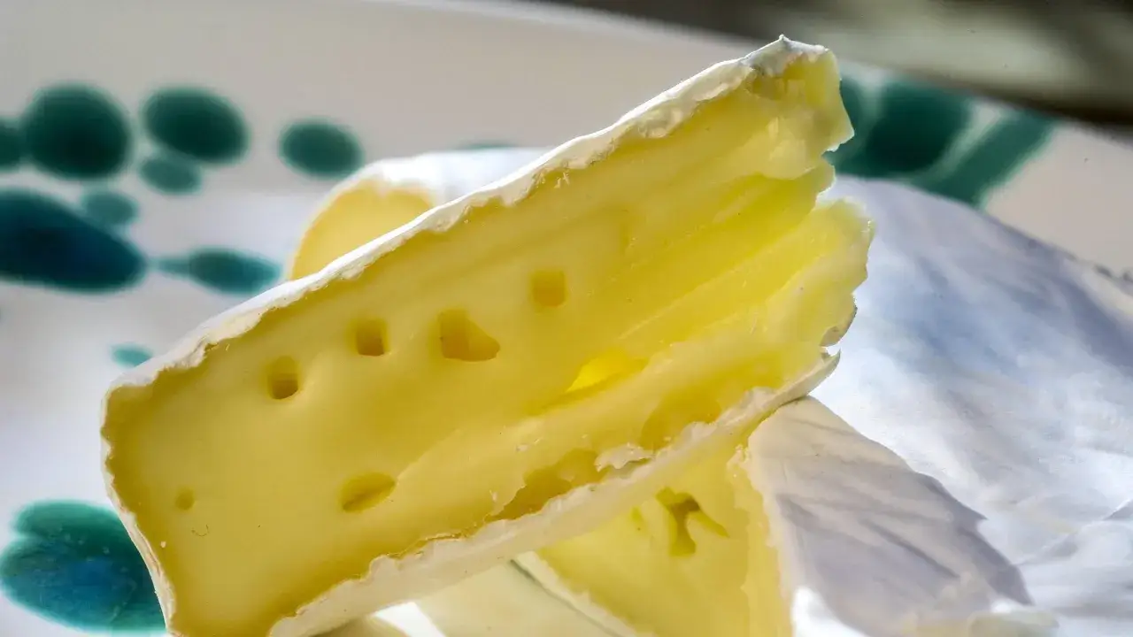 Ein Stück cremiger Camembert mit Rinde, das an Schwangerschaftsgelüste erinnert.